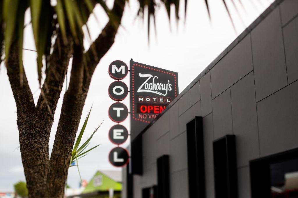 a sign on the side of a building with a tree at Zachary's Motel in Levin