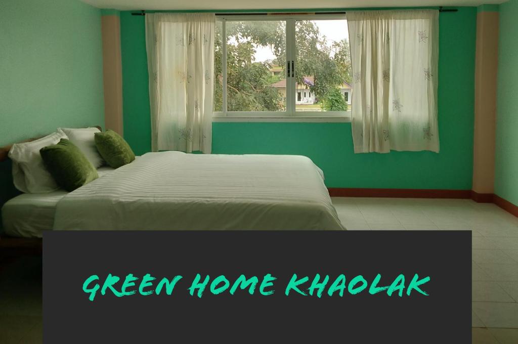 een slaapkamer met een groen khabulk met een bed bij Green Home in Khao Lak