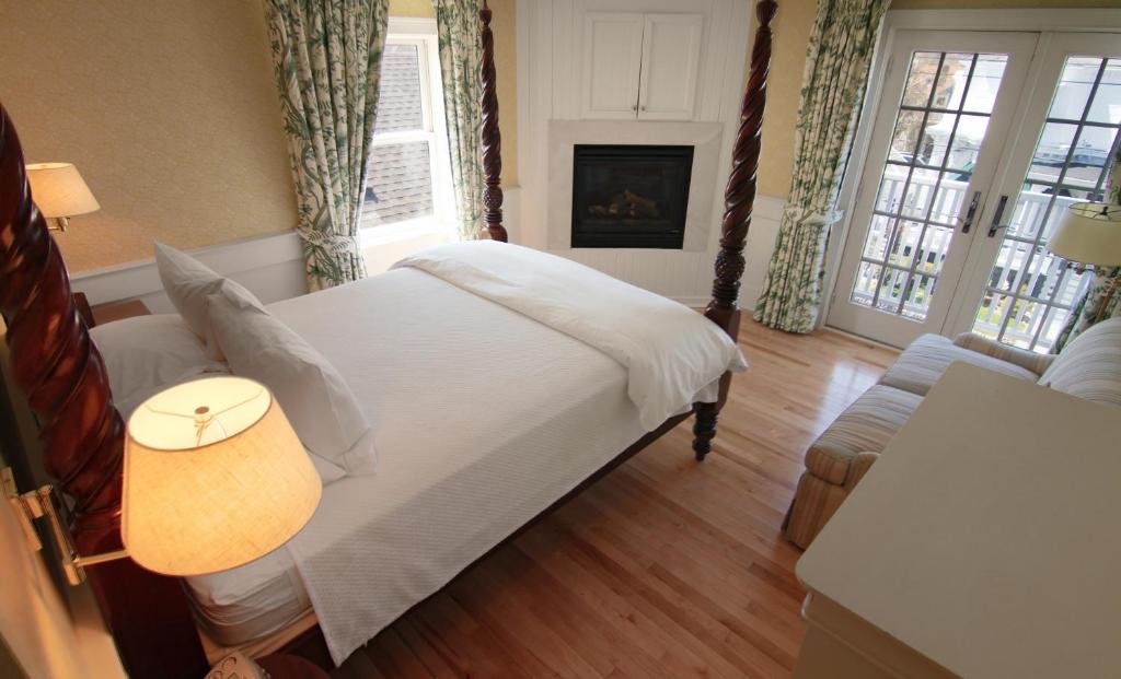 a bedroom with a bed and a couch and windows at Anchor Inn Beach House in Provincetown