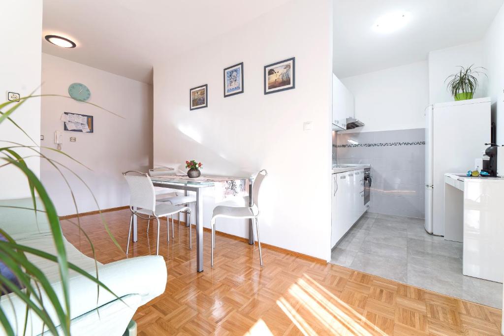 uma cozinha e sala de jantar com mesa e cadeiras em Apartment DORA Split em Split