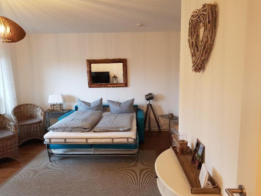 Schlafzimmer mit einem Bett und einem Spiegel an der Wand in der Unterkunft Fewo Aurora in Hahnenklee-Bockswiese