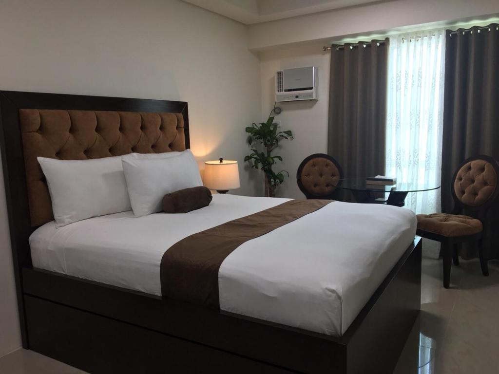 um quarto com uma cama grande, uma mesa e cadeiras em Studio Unit at The Beacon Makati em Manilla