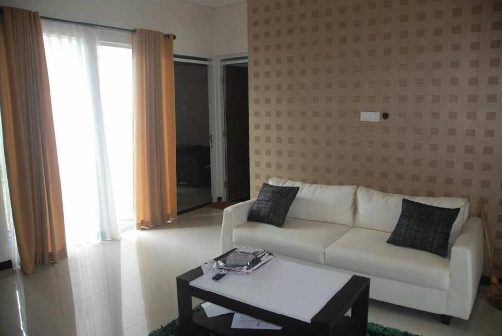 ein Wohnzimmer mit einem weißen Sofa und einem Couchtisch in der Unterkunft Resort Faza in Garut