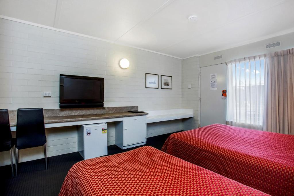 a room with a bed and a desk with a television at Econo Lodge Portland in Portland