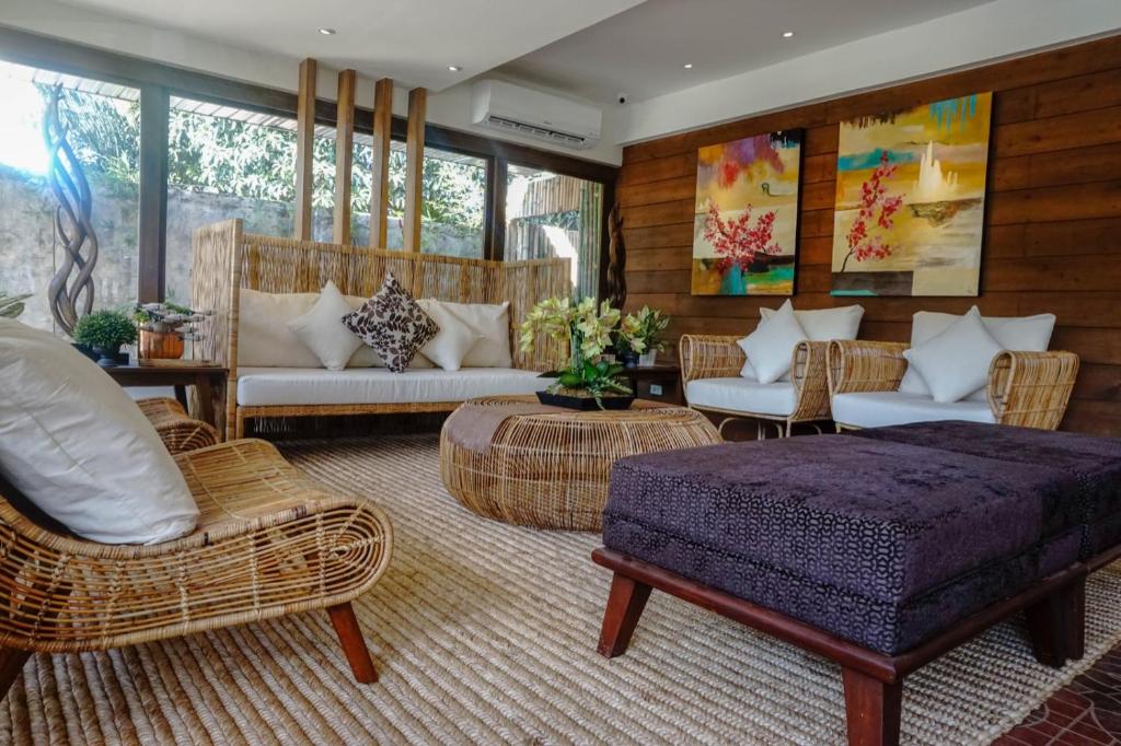 uma sala de estar com uma cama e mobiliário de vime em Balai Princesa em Puerto Princesa