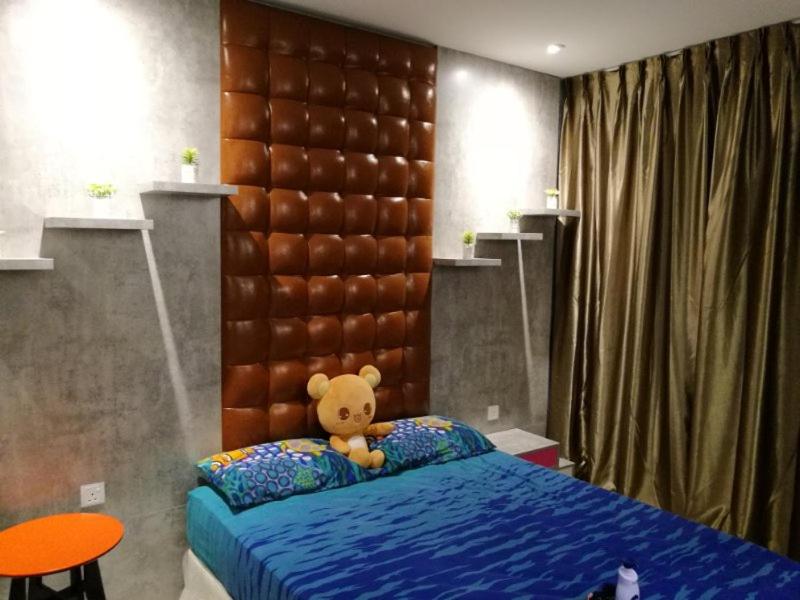 a teddy bear sitting on a bed in a bedroom at Vince's ICity Soho Homestay water park red carpet shah alam light city central in Shah Alam