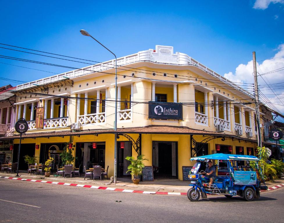 un camion blu parcheggiato di fronte a un edificio di Inthira Thakhek a Thakhek