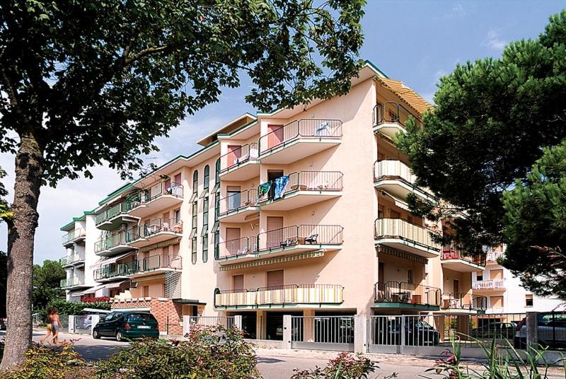 a large pink building with balconies on the side of it at Linz in Bibione