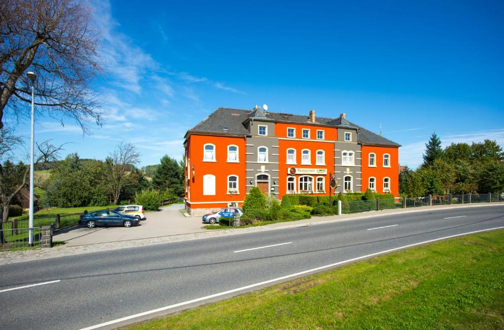 a large orange building on the side of a road at Jägerhof Putzkau in Putzkau