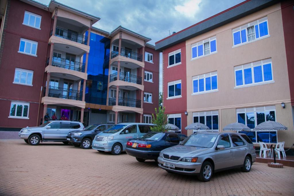 a group of cars parked in a parking lot in front of buildings at Red Sox Hotel Ltd in Kampala