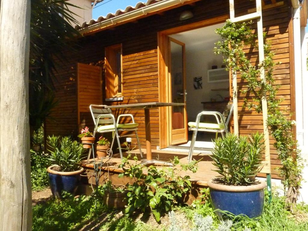 une terrasse couverte avec des chaises et des plantes dans l'établissement Studio dans jardin, à Sète