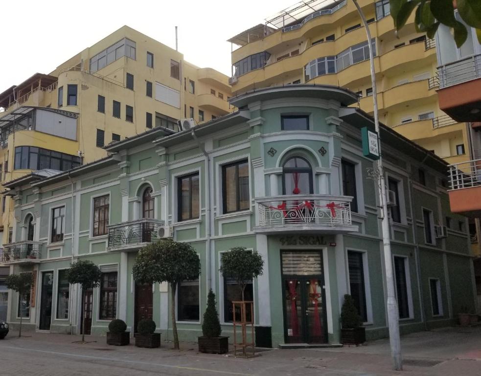 un edificio verde frente a algunos edificios en Vila Sigal Pogradec, en Pogradec