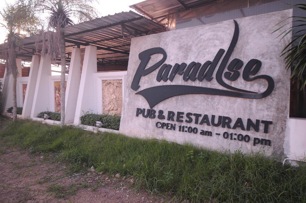 um sinal para um posto pueblo e restaurante em Paradise Inn and Dining em Saraburi