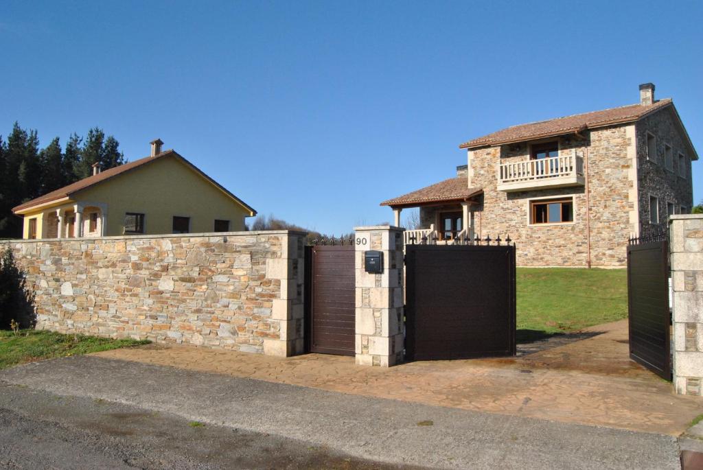 een huis met een poort en een stenen muur bij Casa Loisiana in O Pino 