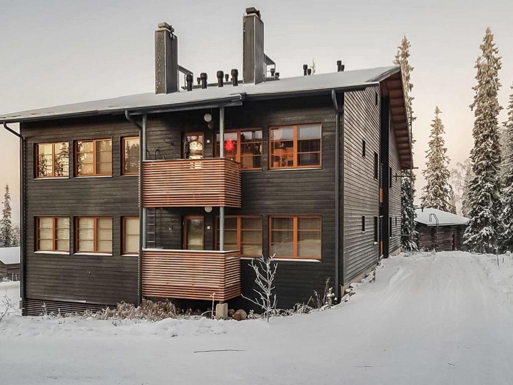 una casa in legno nella neve nel cortile di Holiday Home Karhunvartijan linna c17 by Interhome a Ruka