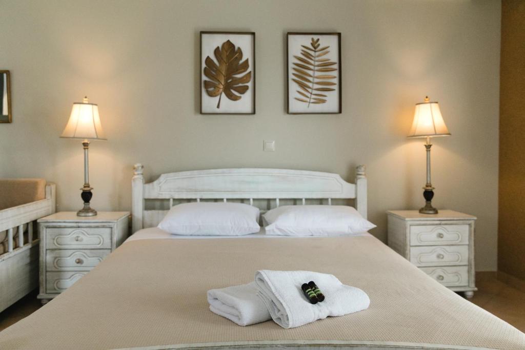 納弗帕克托斯的住宿－Ammos Boutique Hotel，一间卧室配有两张带毛巾和两盏灯的床。