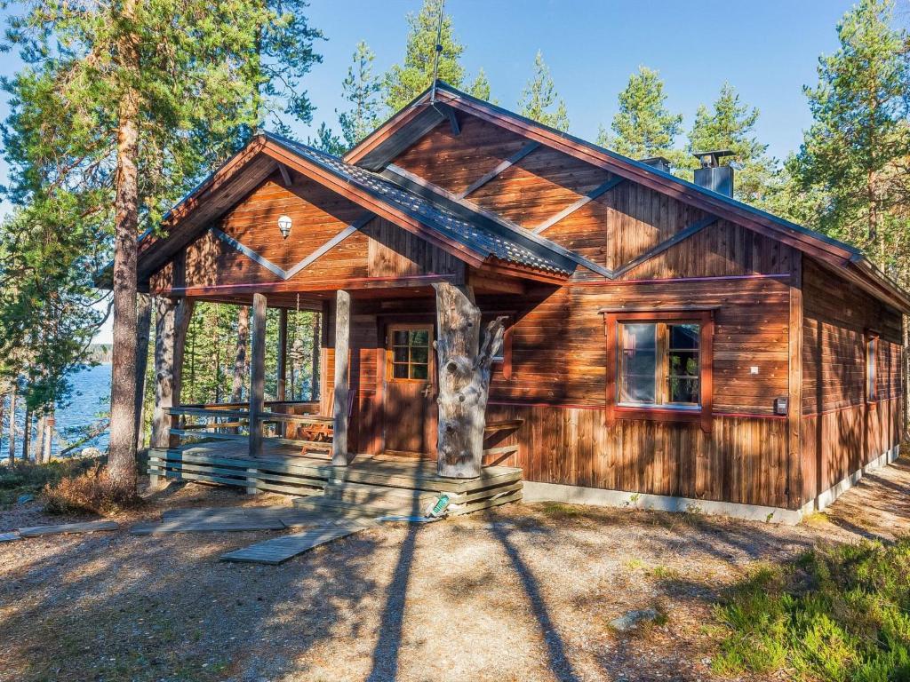 a log cabin with a tree in front of it at Holiday Home Huljakka by Interhome in Lipinlahti