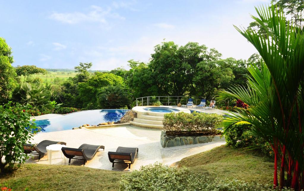 a swimming pool in a yard with chairs around it at Finca El Jecho in Villavicencio