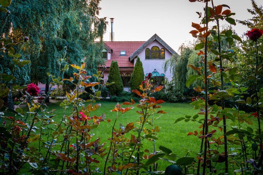 een huis met een tuin met groen gras en bloemen bij Daiconi Boutique House in Miniş