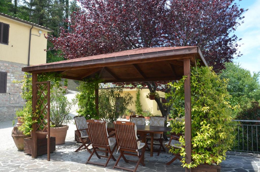 a wooden gazebo with chairs and a table at B&B La Terrazza Del Subasio in Assisi