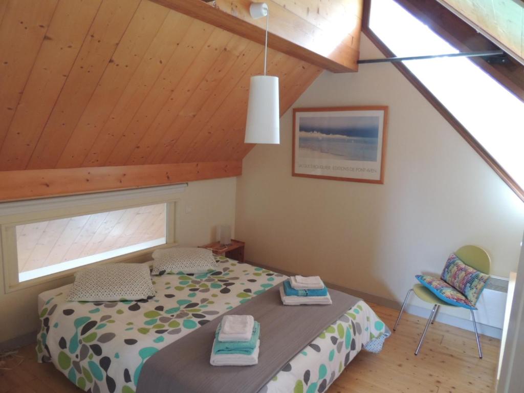 - une chambre avec un lit et une chaise dans l&#39;établissement La maison des bois flottés, à Guérande