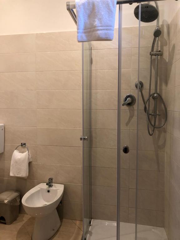 a bathroom with a shower with a toilet and a sink at Hotel Chopin in Fiumicino