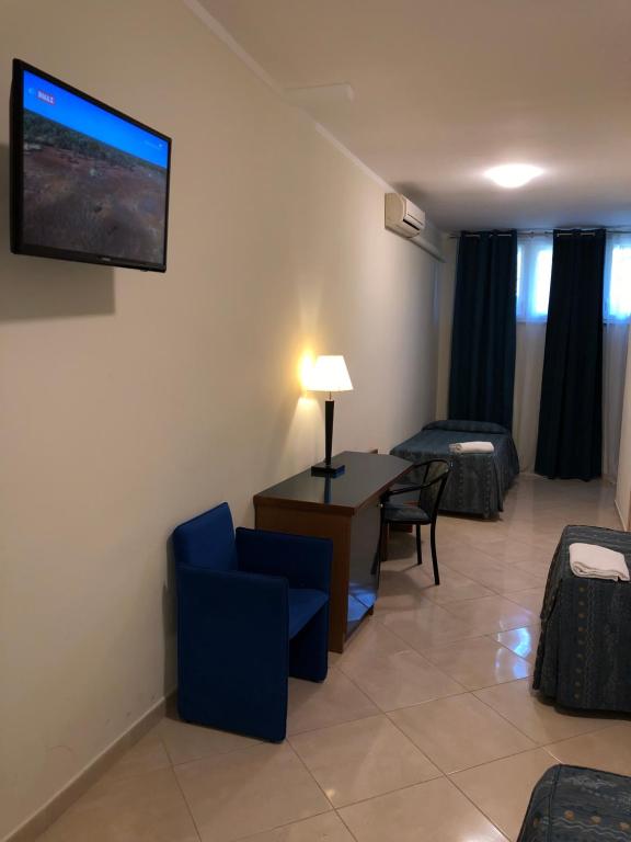 a living room with a tv on the wall at Hotel Chopin in Fiumicino