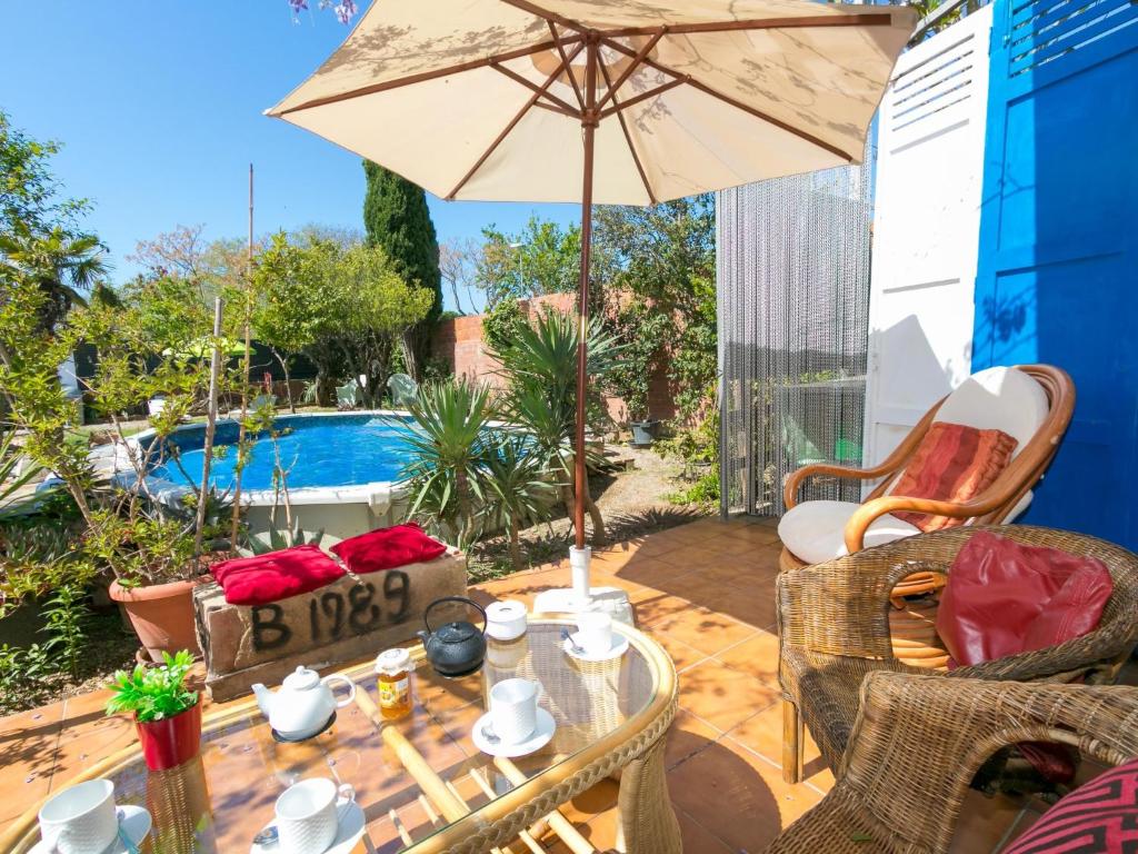 a patio with a table with an umbrella and a pool at Holiday Home Ave de Paso by Interhome in Fortiá