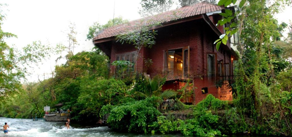 une maison au milieu d'une rivière à côté d'une maison dans l'établissement Theripplingedge, à Karjat