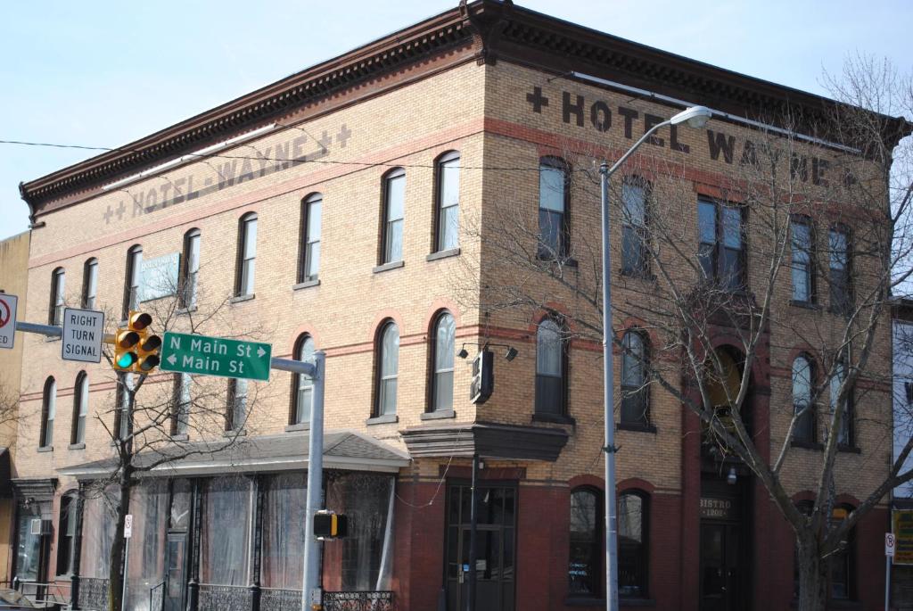 un viejo edificio de ladrillo en una esquina con un semáforo en Hotel Wayne, en Honesdale