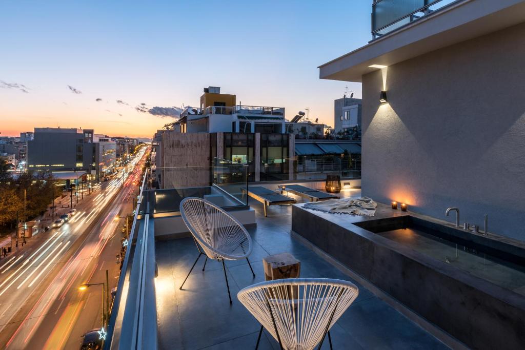 d'un balcon avec des chaises et une vue sur la ville. dans l'établissement Hub Suites, Luxury living in Athens, à Athènes