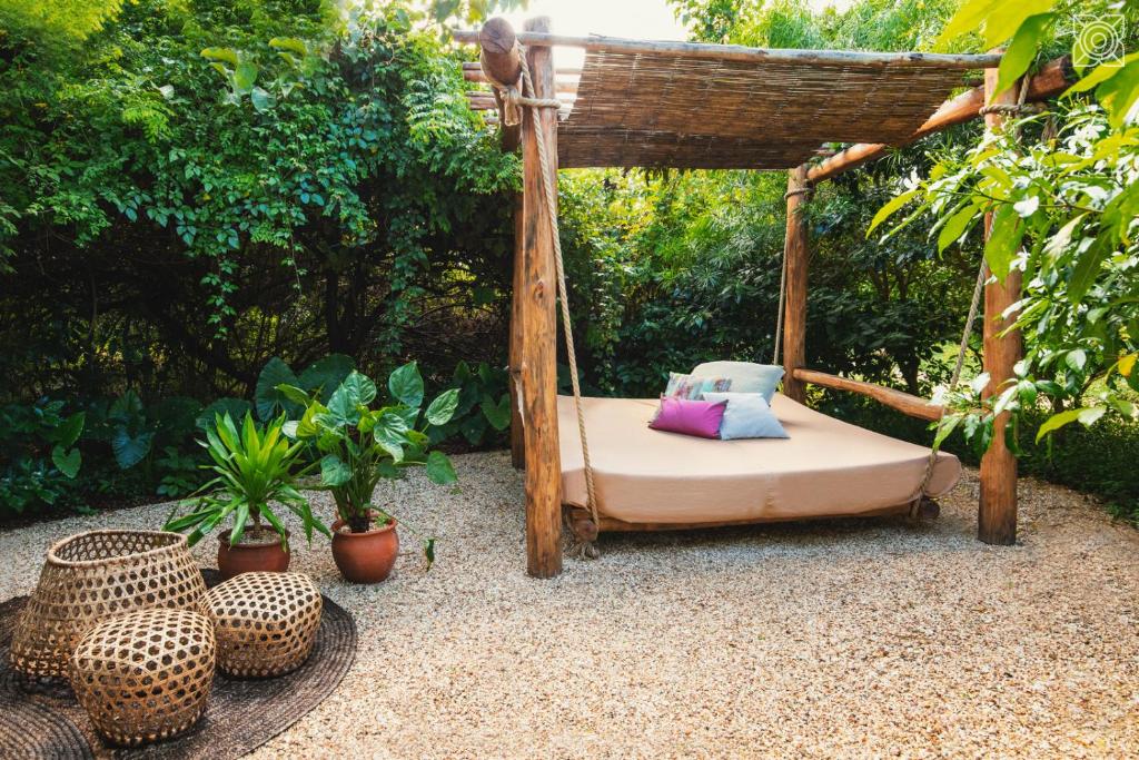 a bed in a gazebo in a garden at Zuri Zanzibar in Kendwa