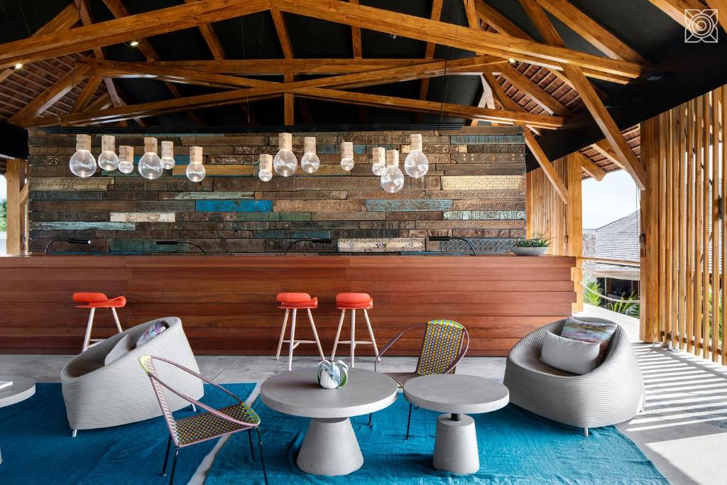 a patio with tables and chairs and a bar at Zuri Zanzibar in Kendwa