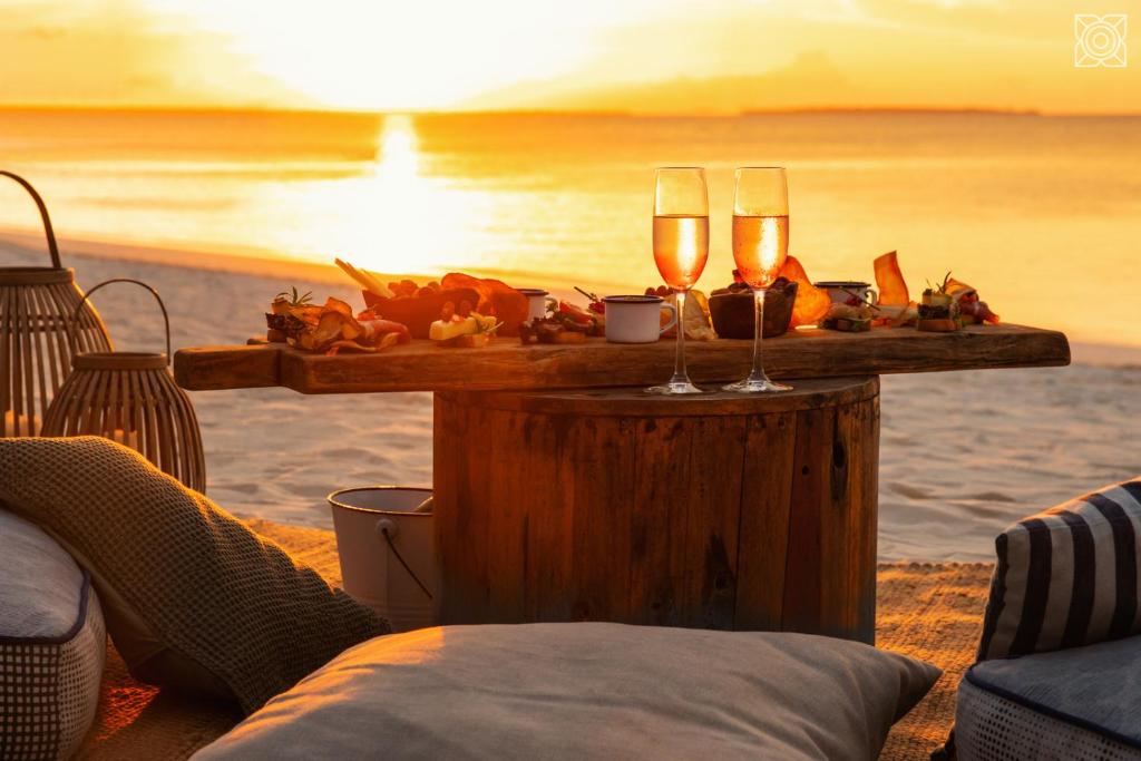 a table with two glasses of wine on the beach at Zuri Zanzibar in Kendwa