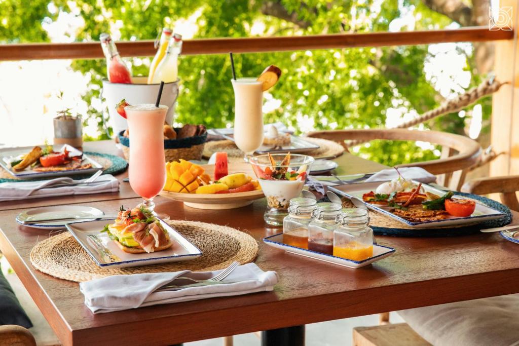 a table topped with plates of food and drinks at Zuri Zanzibar in Kendwa