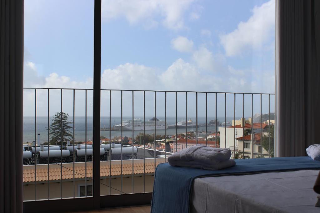 un dormitorio con una gran ventana con un tren en las vías en Solar do Ribeiro, en Funchal