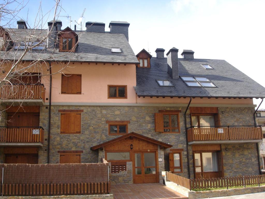 a large stone house with a gambrel roof at Apartamentos wifi Baqueira & Aigüestortes con jardín privado in Esterri d'Àneu