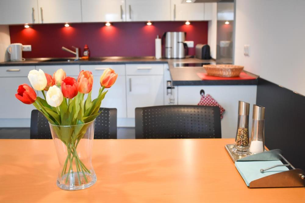 un jarrón de flores sentado en una mesa de madera en Ferienwohnung Ostseestern, en Scharbeutz