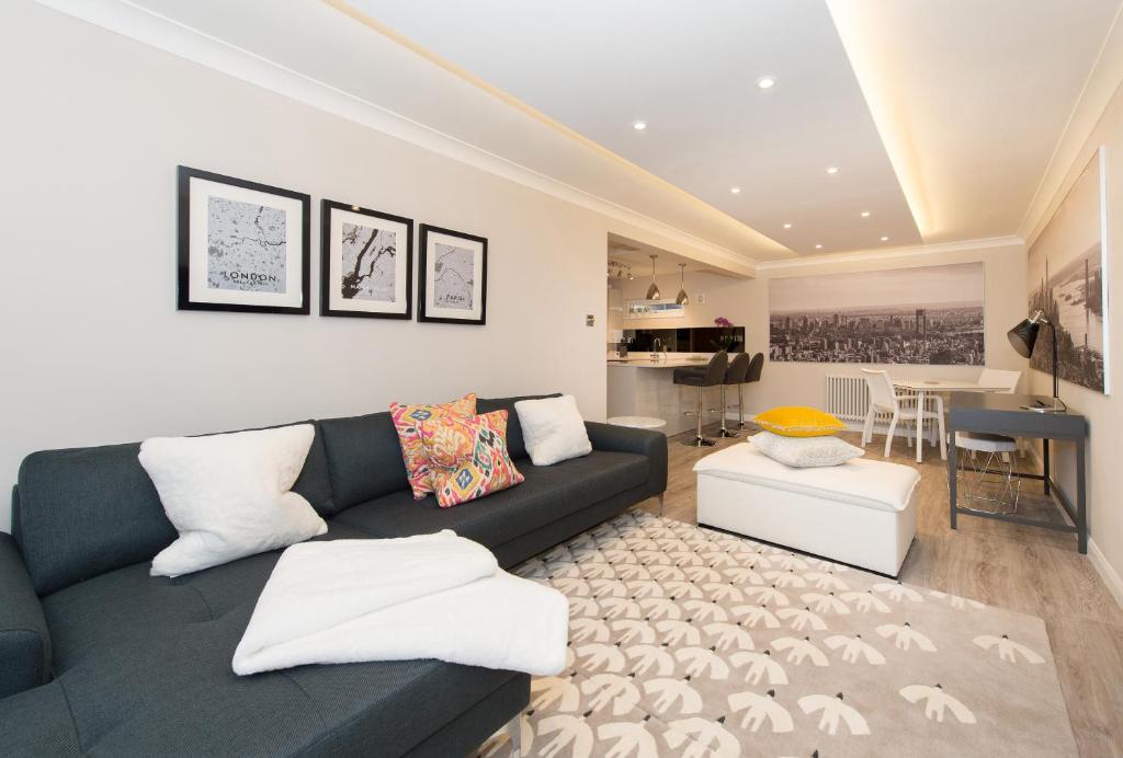 a living room with a black couch and a table at The Mews, York Place by Harrogate Serviced Apartments in Harrogate