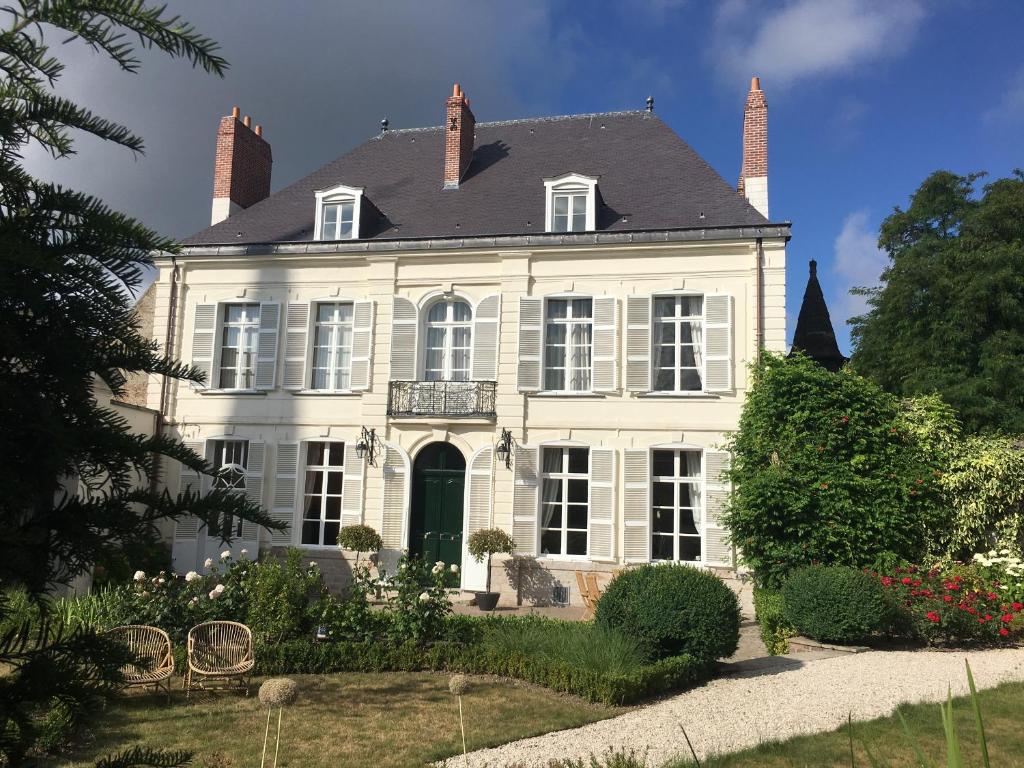 uma grande casa branca com um telhado preto em Entre Cour et Jardin em Arras