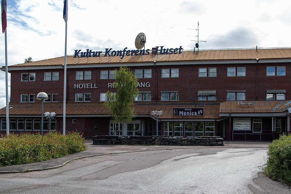 een groot gebouw van rode baksteen met een hotel bij Hotell Monica in Hagfors