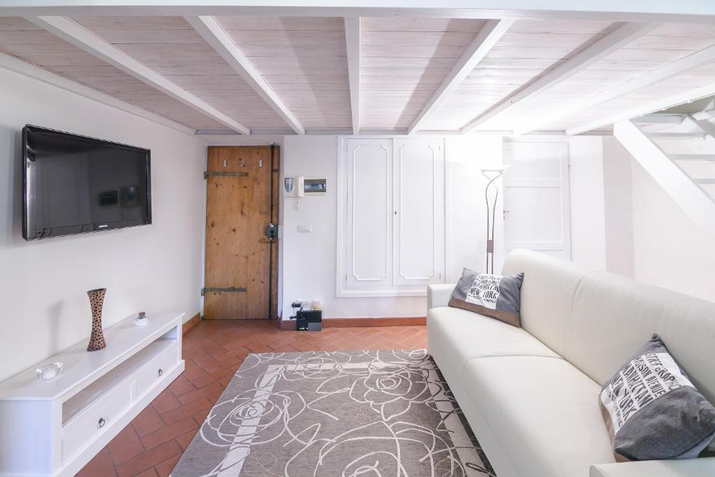 ein Wohnzimmer mit einem weißen Sofa und einem TV in der Unterkunft San Niccolò Loft in Florenz