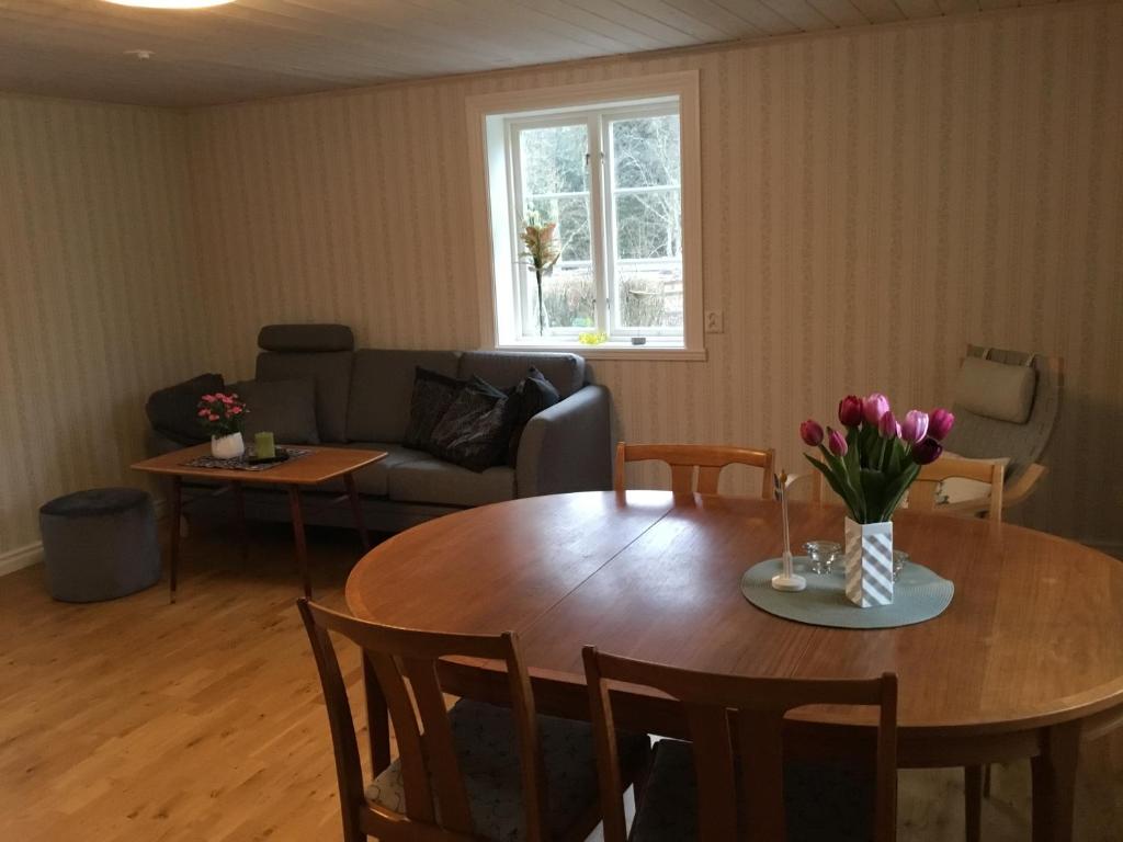 una sala de estar con una mesa de madera con flores. en Stuga Linnebråten, en Värnamo