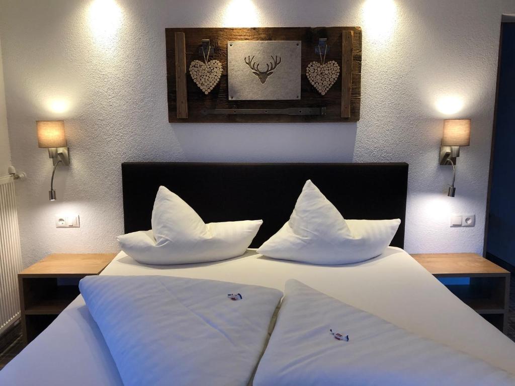 1 dormitorio con 1 cama con sábanas y almohadas blancas en Gästehaus Hackl en Sautens