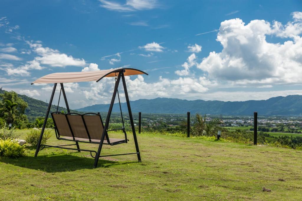 einem Schaukelstuhl mit Schirm auf einem Feld in der Unterkunft Sunrise Forest in Fenglin
