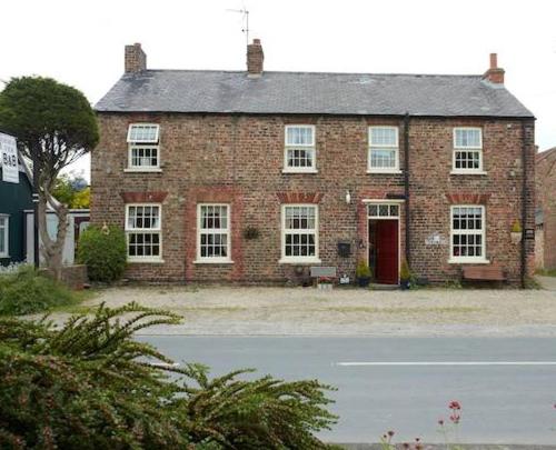 una vieja casa de ladrillo con una puerta roja en una calle en Church View B&B & Holiday Cottages en York
