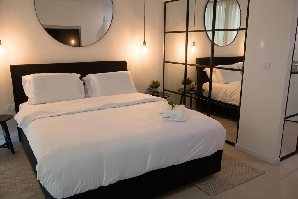 1 dormitorio con 1 cama grande y espejo en Suite Caesar - Neot Golf, en Cesarea