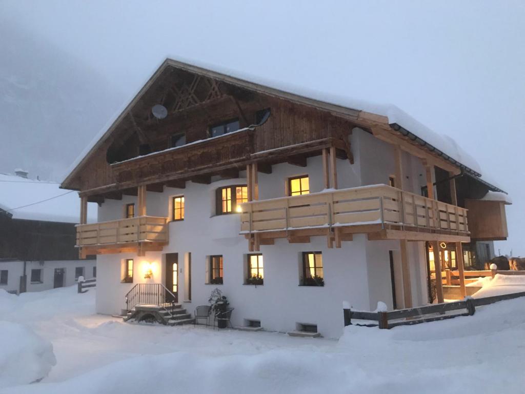 ein Haus im Schnee mit eingeschaltetem Licht in der Unterkunft Gruebe-Hof in Niederthai