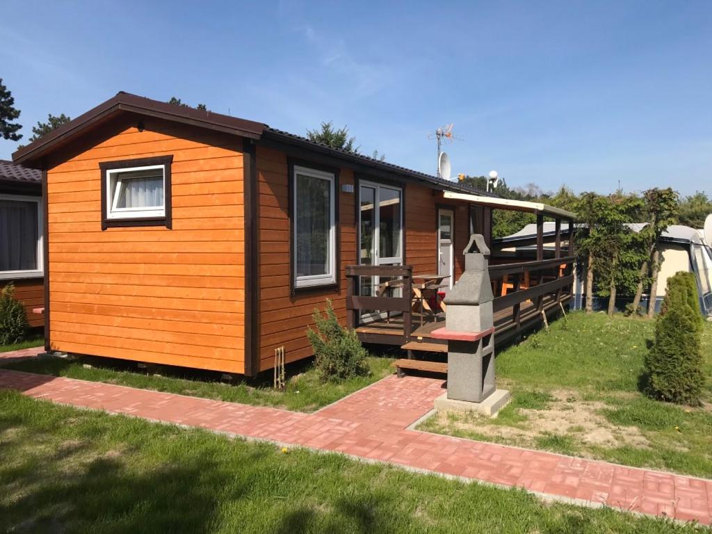 a tiny house with a porch and a grave at Domek Parterowy in Gąski