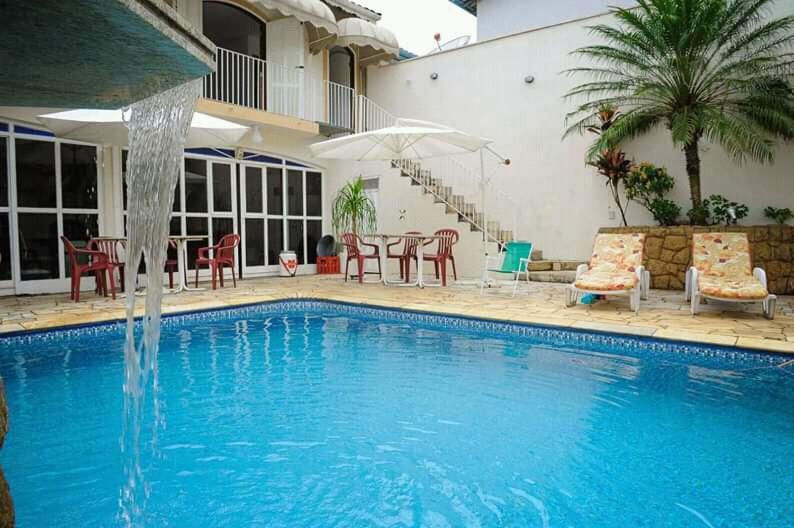 una piscina con una fuente frente a una casa en Residencial Aconchego, en Socorro